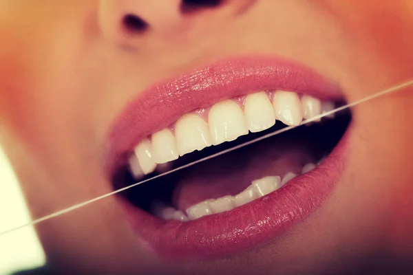 Wanita menggunakan benang gigi. — Stok Foto
