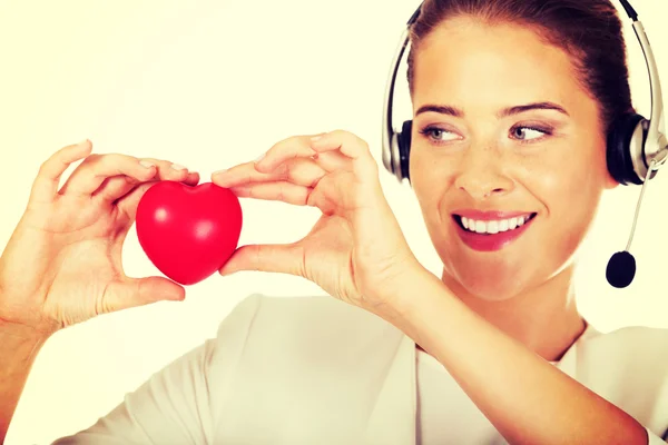 Happy call center woman with heart toy — Stock Photo, Image