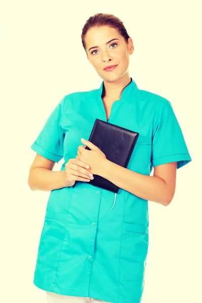Young female doctor or nurse holding black notes — Stock Photo, Image