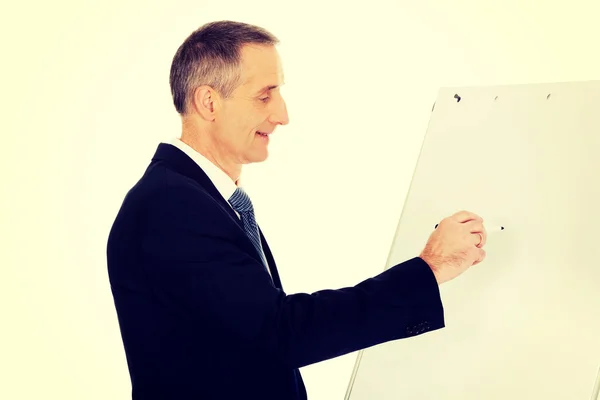Escrita executiva masculina em um flipchart — Fotografia de Stock