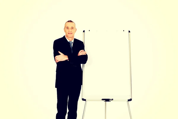 Uomo esecutivo in piedi vicino a flip chart — Foto Stock