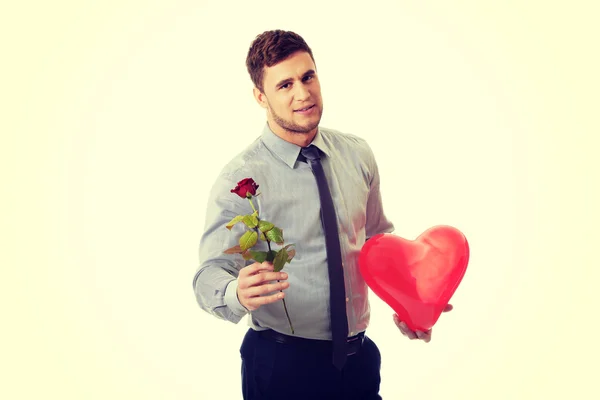 Egy vörös rózsa és a szív ballont fiatalember. — Stock Fotó