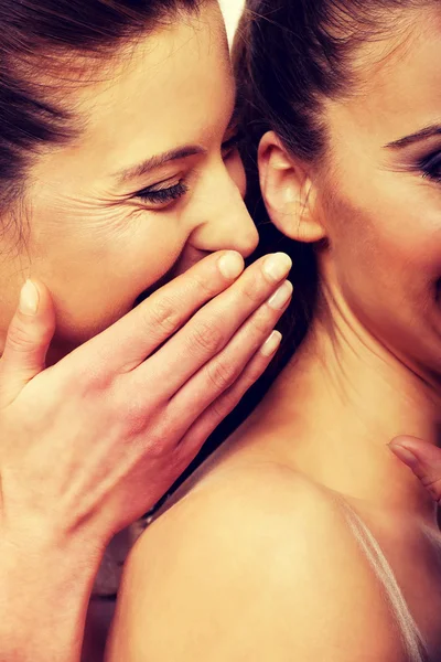 Zwei schöne Frauen flüstern. — Stockfoto