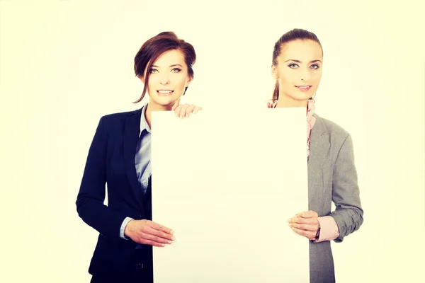 Zwei Geschäftsfrauen mit einer großen weißen Tafel. — Stockfoto