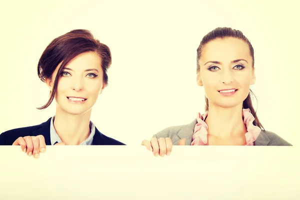 Zwei Geschäftsfrauen mit einer großen weißen Tafel. — Stockfoto