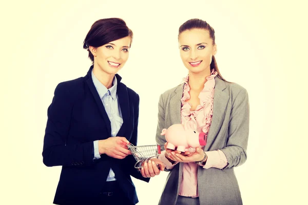 Duas mulheres de negócios com banco porquinho . — Fotografia de Stock