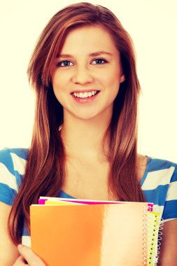 Elinde birkaç defter tutan genç bir kadın.