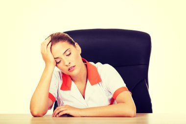 Yorgun doktor masanın arkasında oturan