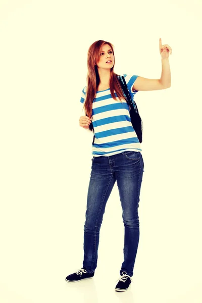 Mujer adolescente con mochila apuntando para calmar —  Fotos de Stock