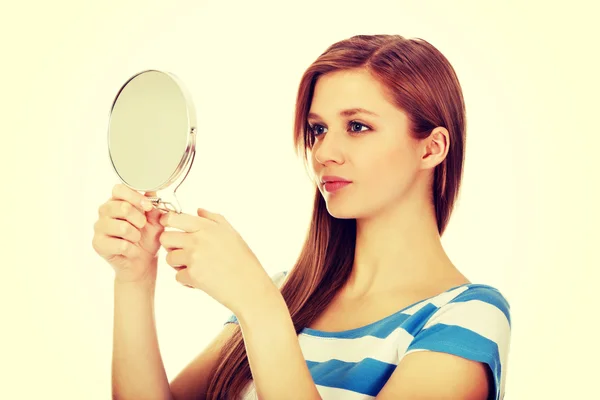 Aynaya bakmak genç güzel kadın — Stok fotoğraf