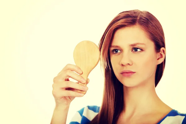 Teenage beautiful woman looking in a mirror — Stock Photo, Image