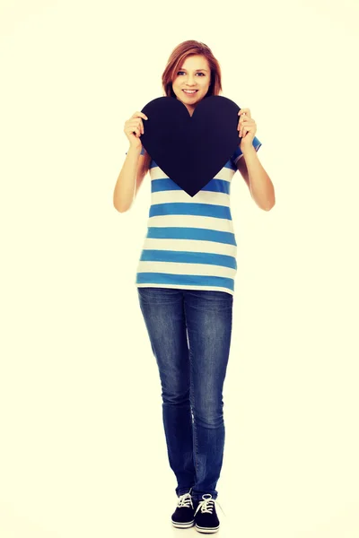 Young teenage woman holding black paper heart — Stock Photo, Image