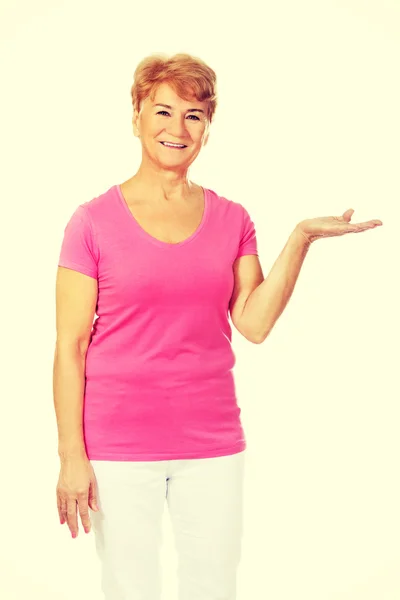 An old smiling woman presenting something — Stock Photo, Image
