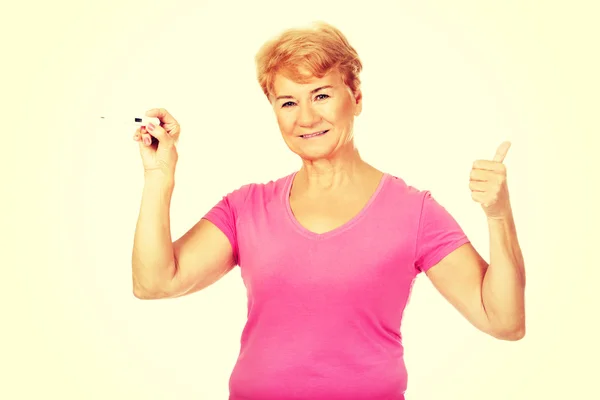 Donna anziana mostra termometro e gesti OK — Foto Stock