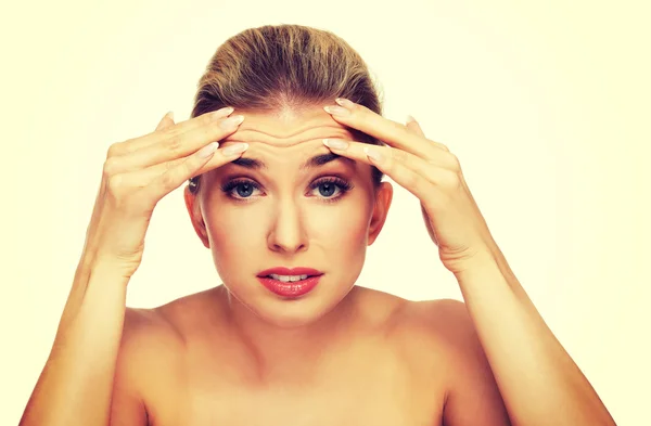 A young woman checking wrinkles on her forehead — Stock Photo, Image