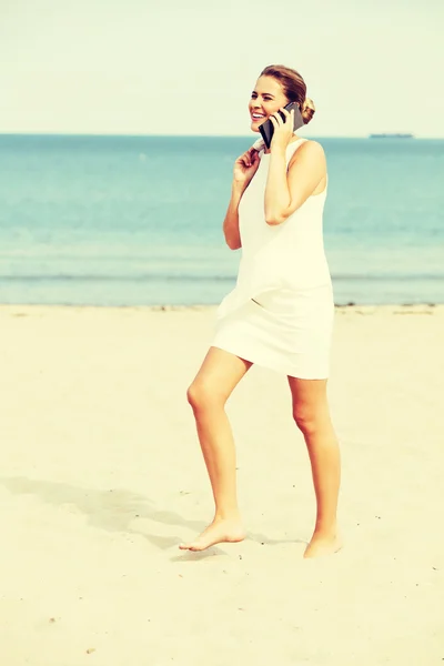 Giovane elegante bella donna che parla al telefono sulla spiaggia — Foto Stock