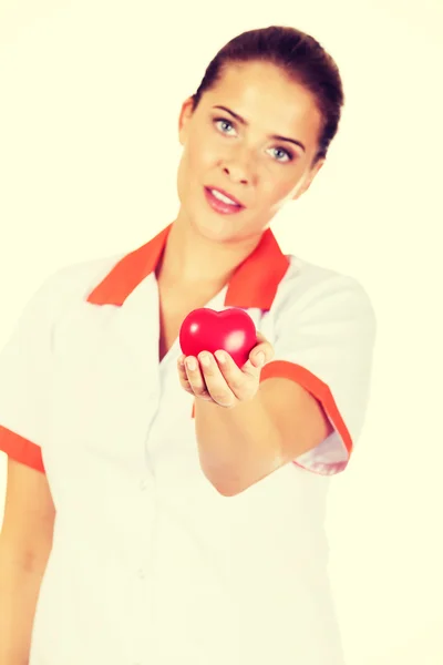 Junge Ärztin oder Krankenschwester mit Spielzeugherz — Stockfoto