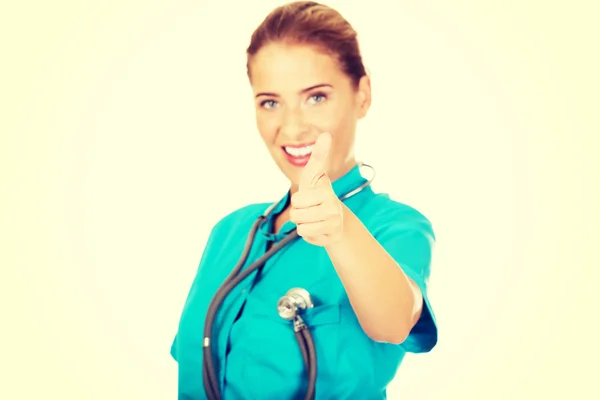 Mladý lékař ukazuje palcem nahoru znamení — Stock fotografie