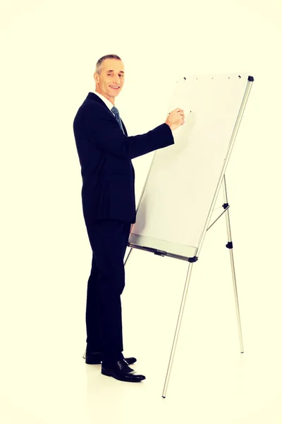 Escrita executiva masculina em um flipchart — Fotografia de Stock