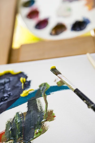 Pincel de pintura com cor e lona — Fotografia de Stock