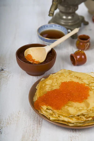 Pancakes with red caviar on a table. — Stock Photo, Image