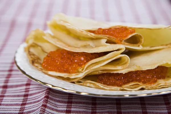 Pancakes with red caviar on a table. — Stock Photo, Image