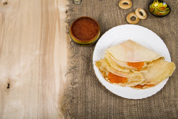Leckere Pfannkuchen mit rotem Kaviar auf einem Tisch — Stockfoto