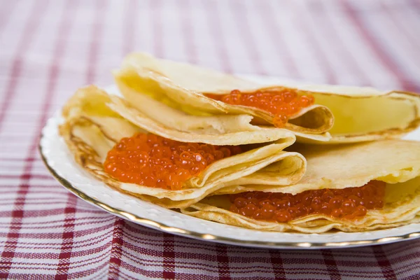 Deliciosos panqueques con caviar rojo sobre una mesa — Foto de Stock