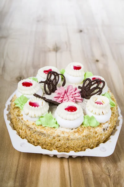 Cake with cream on a wooden table — Stock Photo, Image