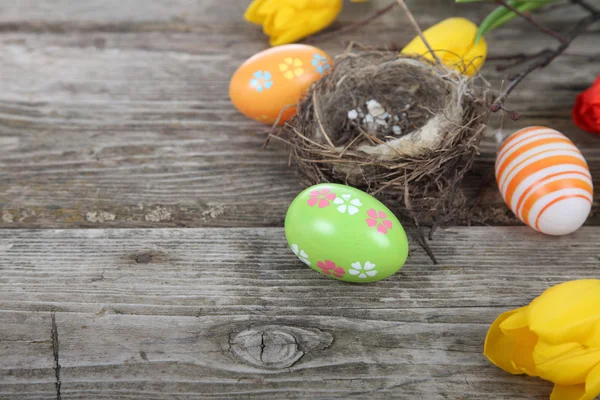 Ostereier im Nest auf einem hölzernen Hintergrund — Stockfoto