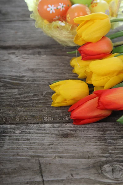 Strauss aus gelben und roten Tulpen und Ostereiern — Stockfoto