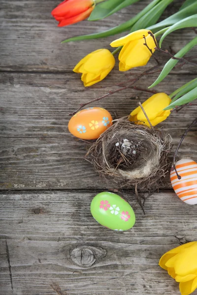 Ostereier im Nest auf einem hölzernen Hintergrund — Stockfoto