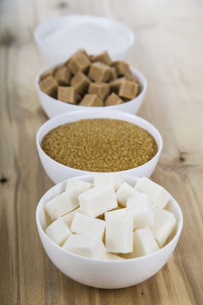 Sockerrör och vitt socker i en vita skålar — Stockfoto
