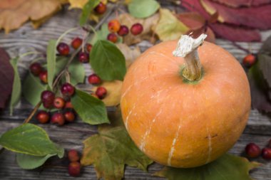 Kabaklar ve ahşap bir masa üzerinde sonbahar yaprakları 