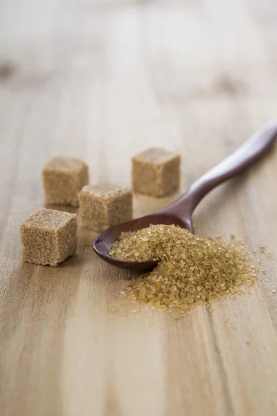 Cukier trzcinowy w drewnianą łyżką — Zdjęcie stockowe