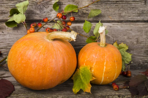 Pumpkins and fall leaves on wooden table — Stock Photo, Image