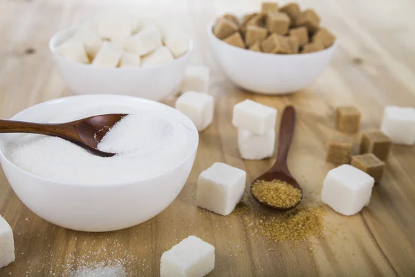 Cane and white sugar in a white bowls