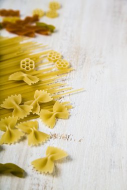 Pişmemiş makarna ve baharat ahşap arka plan üzerinde