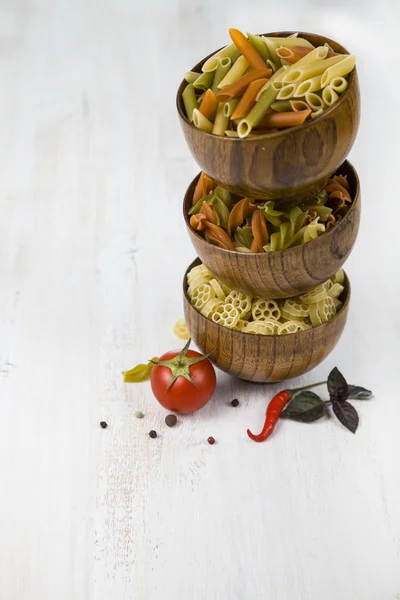 Raw pasta in wooden bowls and spices