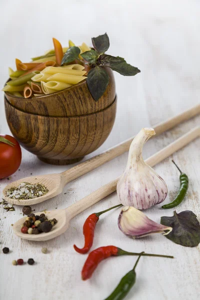 Raw pasta in wooden bowls and spices — Stock Photo, Image