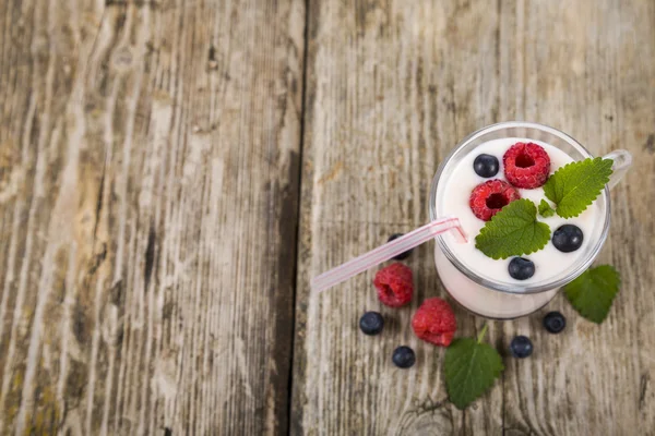 Smoothie com mirtilos e framboesas em uma mesa de madeira — Fotografia de Stock