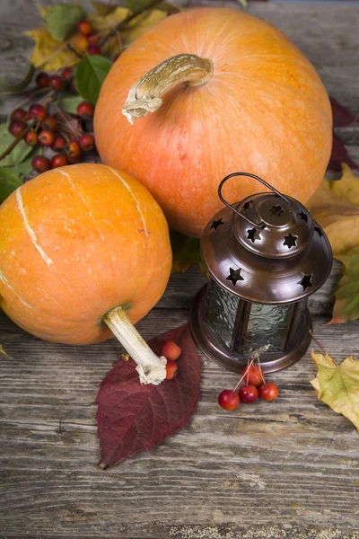 Pumpkins,lantern and fall leaves on a wooden table — Stock Photo, Image