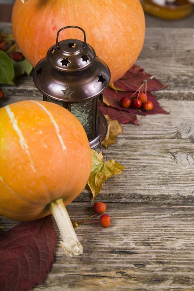 Pumpkins,lantern and fall leaves on a wooden table — Stock Photo, Image