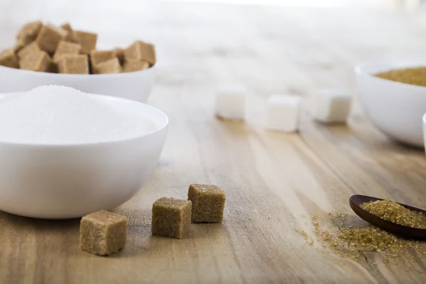 Cane and white sugar in a white bowls