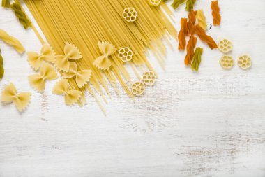 Pişmemiş makarna ve baharat ahşap arka plan üzerinde