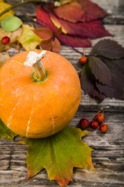 Kabaklar ve ahşap bir masa üzerinde sonbahar yaprakları 