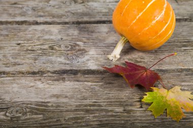 Kabaklar ve ahşap bir masa üzerinde sonbahar yaprakları 