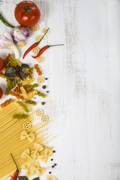 Raw pasta and spices on a wooden table — Stock Photo, Image