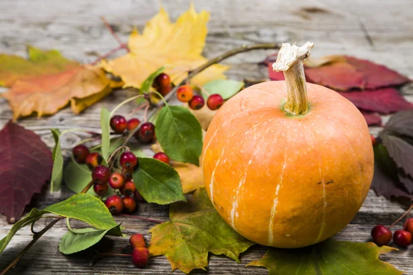 Pumpkins and fall leaves on a wooden table — Stock Photo, Image