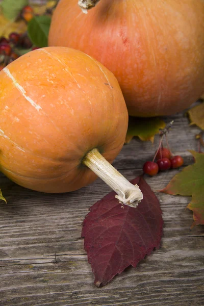 Pumpkins and fall leaves on an old wooden table — Stock Photo, Image